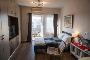 a bedroom with a bed and a tv and a window at City Kiss in Orestiada