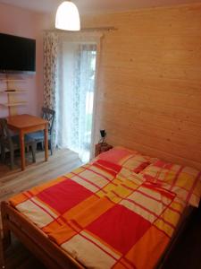 a bedroom with a bed with a colorful blanket on it at Pokoje 64 in Ustroń
