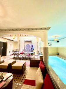 a living room with a swimming pool and a table at Riad Atlas Toyours in Marrakesh