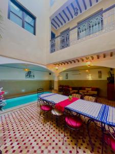 a room with two tables and a swimming pool at Riad Atlas Toyours in Marrakesh