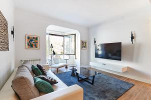 a living room with a couch and a flat screen tv at TuApartamento Boutique & Art - Plaza de Toros in Pamplona