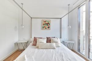 a large white bed in a white room with windows at TuApartamento Boutique & Art - Plaza de Toros in Pamplona