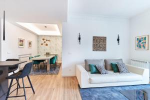 a living room and dining room with a white couch at TuApartamento Boutique & Art - Plaza de Toros in Pamplona