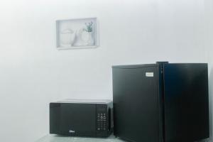 a microwave sitting next to a black refrigerator at Céntrico y Confortable in Comayagua