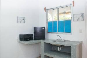 a kitchen with a sink and a microwave at Céntrico y Confortable in Comayagua