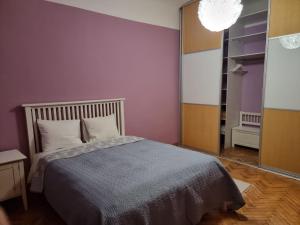 a bedroom with a bed and a purple wall at City Inn 2 Bedroom Apartment next to City Hall with parking in Rīga