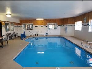 a large swimming pool with blue water in a building at Omak Inn in Omak