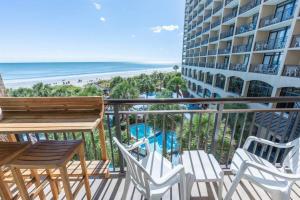 a balcony with chairs and a table and a view of the beach at Your Beachfront Resort Oasis in Myrtle Beach