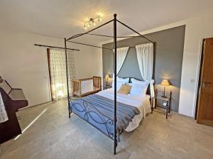 1 dormitorio con cama con dosel y sábanas azules en Villa Les Agrions avec piscine, en Le Thoronet