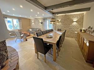cocina y sala de estar con mesa de madera y sillas en Villa Les Agrions avec piscine, en Le Thoronet