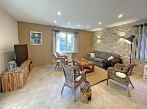 sala de estar con sofá y TV en Villa Les Agrions avec piscine, en Le Thoronet