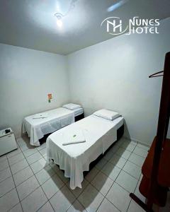 Postel nebo postele na pokoji v ubytování Nunes Hotel