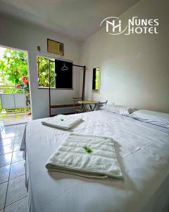 パルマスにあるNunes Hotelのタオルが敷かれたベッドのあるホテルの部屋