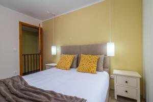 a bedroom with a large bed with yellow walls at Casa da Professora By ALzira in Seia