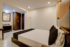ein Schlafzimmer mit einem großen Bett und einem TV in der Unterkunft Super OYO Flagship Hotel Golden Nest in Saravli