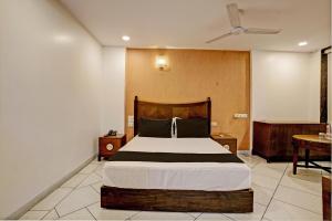 a bedroom with a large bed and a table at Super OYO Flagship Hotel Golden Nest in Saravli