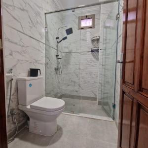 Bel appartement de 2 chambres في مراكش: حمام مع مرحاض ودش زجاجي