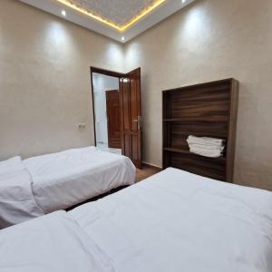 Bel appartement de 2 chambres في مراكش: غرفة فندقية بسريرين ومرآة