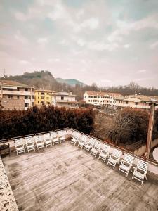 a group of white chairs sitting on a deck at Hotel Battaglia in Battaglia Terme