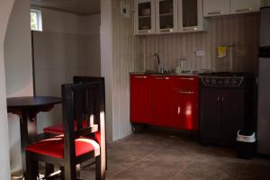 a kitchen with red cabinets and a red chair at Cabaña Maribel encanto in Filandia