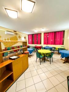 ein Restaurant mit Tischen, Stühlen und roten Vorhängen in der Unterkunft Hotel Battaglia in Battaglia Terme