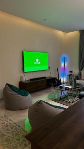 a living room with a flat screen tv on a wall at Urban Bunks - Riyadh in Riyadh