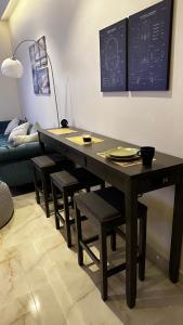 a dining room table with chairs and a chalkboard on the wall at Urban Bunks - Riyadh in Riyadh