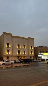 利雅德的住宿－Urban Bunks - Riyadh，停车场内停放汽车的大型建筑