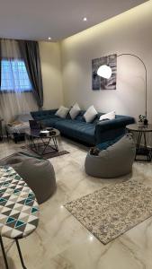 a living room with a blue couch and a table at Urban Bunks - Riyadh in Riyadh