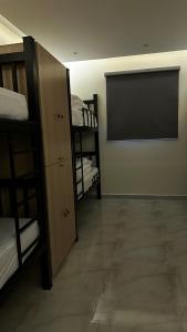 um quarto com beliches e uma televisão de ecrã plano em Urban Bunks - Riyadh em Riyadh