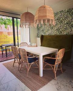 a dining room with a white table and chairs at Casa Chic entre Cuernavaca y Tequesquitengo in Alpuyeca