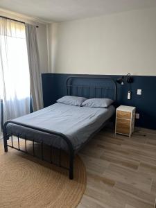 a bed in a bedroom with a blue wall at Casa Chic entre Cuernavaca y Tequesquitengo in Alpuyeca