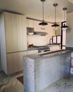 a kitchen with a counter top and a stove at Casa Chic entre Cuernavaca y Tequesquitengo in Alpuyeca