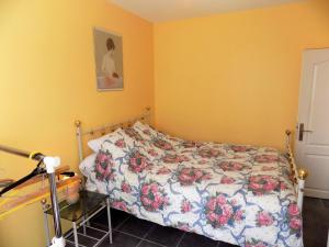 1 dormitorio con 1 cama con colcha de flores en Saint Georges de Didonne - PETITE MAISON avec son petit coin de paradis extérieur en Saint-Georges-de-Didonne
