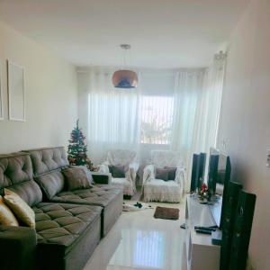 a living room with a couch and a christmas tree at Casa com Piscina perto da praia in Salvador