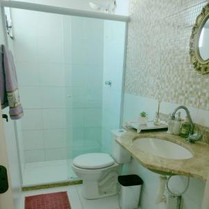 La salle de bains est pourvue de toilettes, d'un lavabo et d'une douche. dans l'établissement Casa com Piscina perto da praia, à Salvador