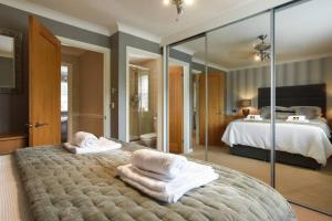 a bedroom with a large bed and a large mirror at Beautiful Meon Valley Family Home in Shedfield