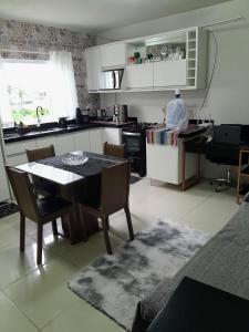 a kitchen with a table and chairs in a room at Hostel bons sonhos Um Quarto uma Cama de Casal in Penha