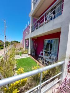 un balcón de una casa con patio en La Ramona Bed & Breakfast en Valeria del Mar