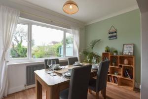 a dining room with a table and chairs and a window at 2 Bed Flat with garden nr Beach in South Hayling