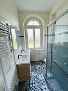 un baño con lavabo y ducha en Gîte de groupe à la Ferme de Verdun, 1H30 de Paris, en Le Héron