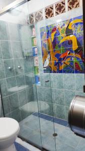 een badkamer met een glazen douche en een toilet bij Hotel Villa Palosanto in Jericó
