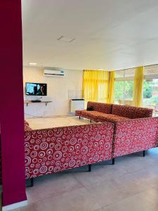 マル・デル・プラタにあるGRAN HOTEL DE LOS ACANTILADOSの赤と白のベッド、薄型テレビが備わる客室です。