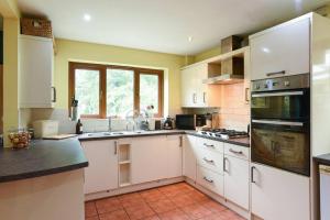 a large kitchen with white cabinets and appliances at Large family home pool table in Waterlooville
