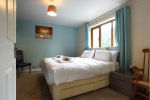 a bedroom with a large white bed with a window at Large family home pool table in Waterlooville