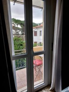 um quarto com uma janela com uma cadeira vermelha no exterior em MIGU POINT Pisa em Pisa