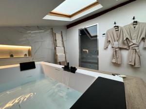 y baño con bañera y albornoz en la pared. en Love & Spa Fréjus, en Fréjus 17 fotos más