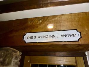 un cartel que lee el Lancatown de la posada colgando sobre una puerta en 16th Cent,6 bed house,15 People en Llangwm-isaf