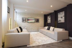 a living room with two couches and a brick wall at Prison Conversion Flat with Parking in Portsmouth