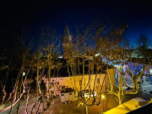 Un gran edificio con una torre de reloj por la noche. en Love & Spa Fréjus, en Fréjus